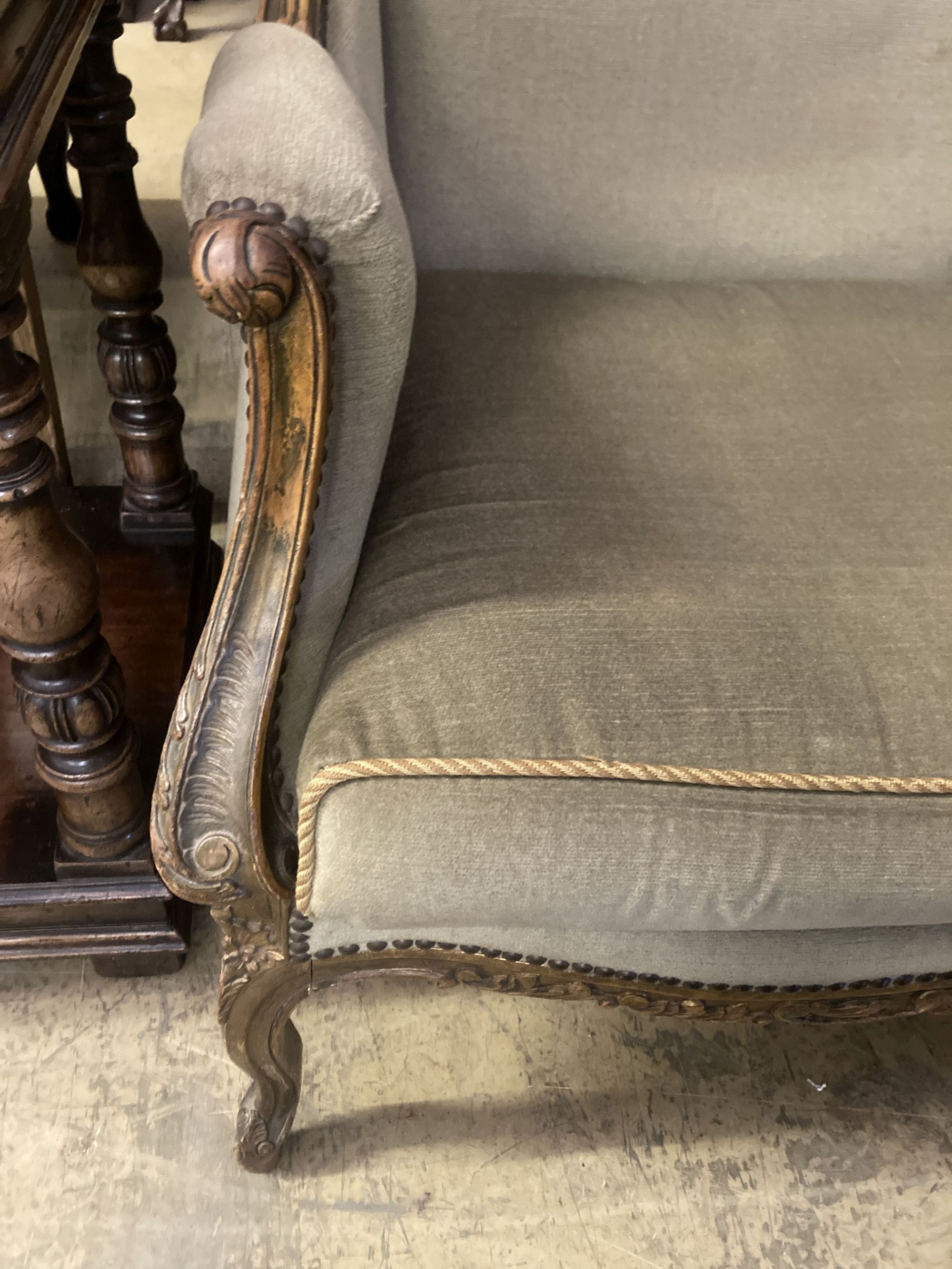 An early 20th century French parcel gilt carved beech wing armchair, width 70cm, depth 66cm, height 115cm